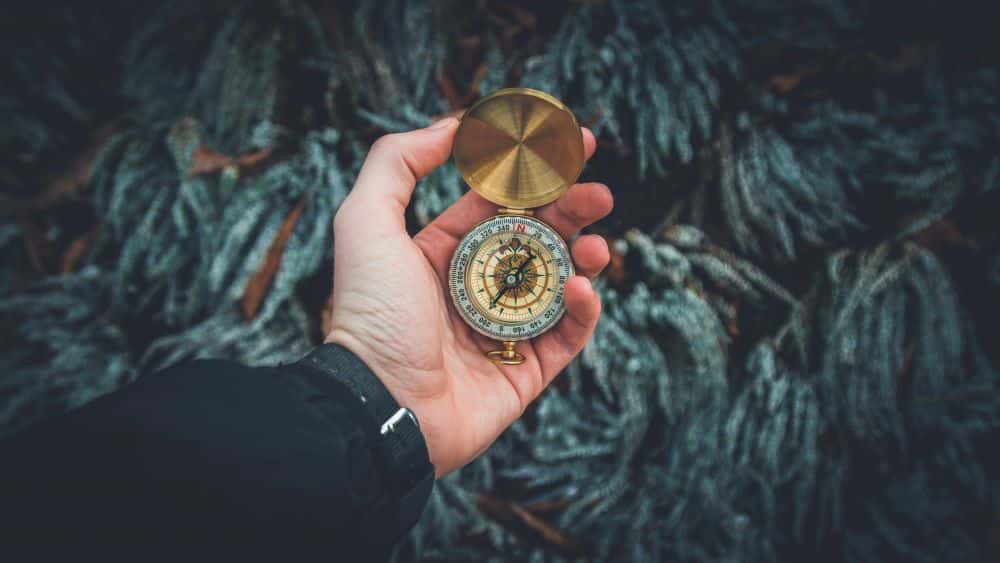 Picture of a man holding a compass, signifying his self-discovery.