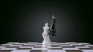Chess pieces crashing together - symbolising ego defence mechanisms