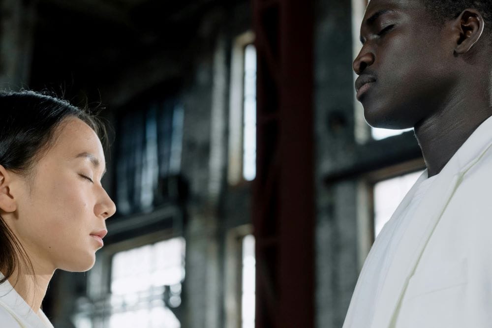 A guy and a girl standing with eyes closed reflecting on their inner transformation journey